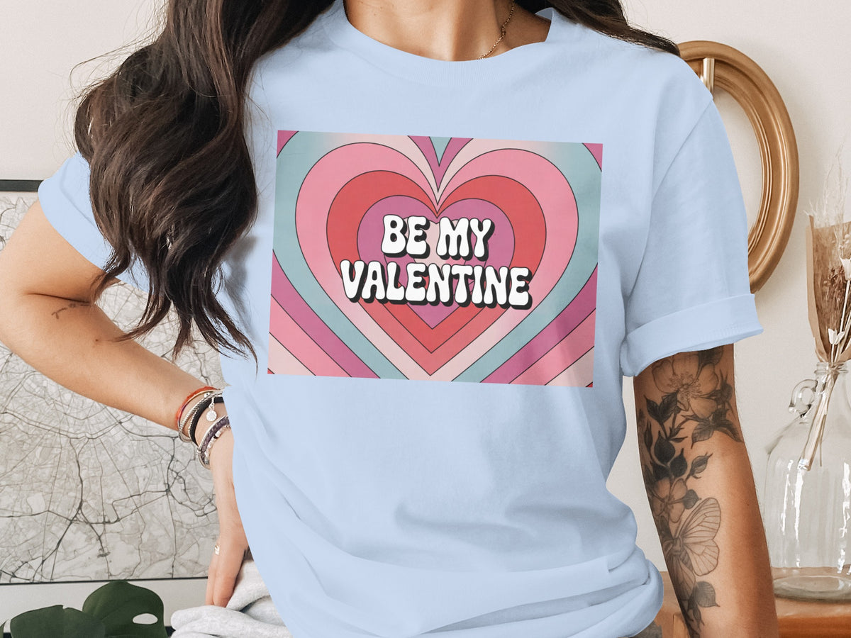 Light blue t-shirt with a groovy heart graphic that reads "Be My Valentine."