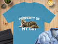 Blue t-shirt with "PROPERTY OF MY CAT" text and a cat illustration.