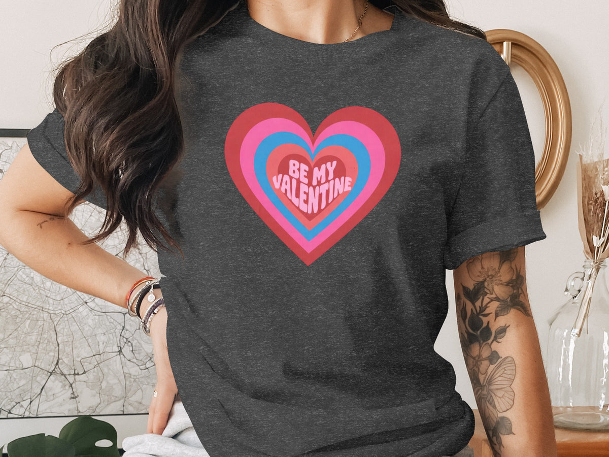Dark grey t-shirt with a colorful heart graphic reading "BE MY VALENTINE".