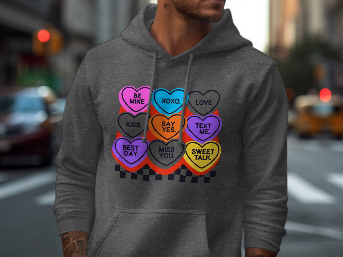 Dark grey hoodie with conversation heart graphic including text like "Be Mine", "XOXO", "Love".
