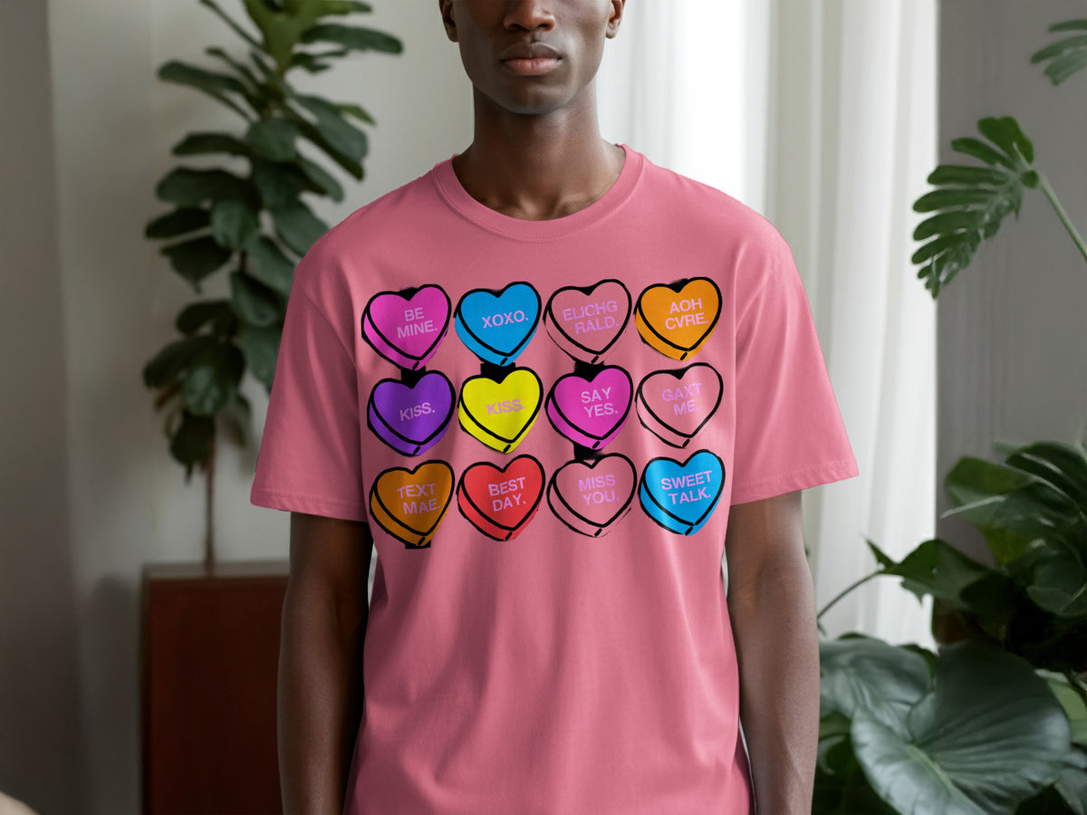 A person wearing a pink t-shirt printed with a grid of colorful candy hearts.