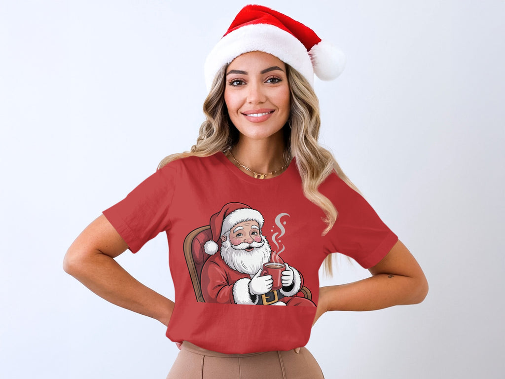 Red t-shirt with Santa Claus illustration holding a mug, worn by a woman in a Santa hat.