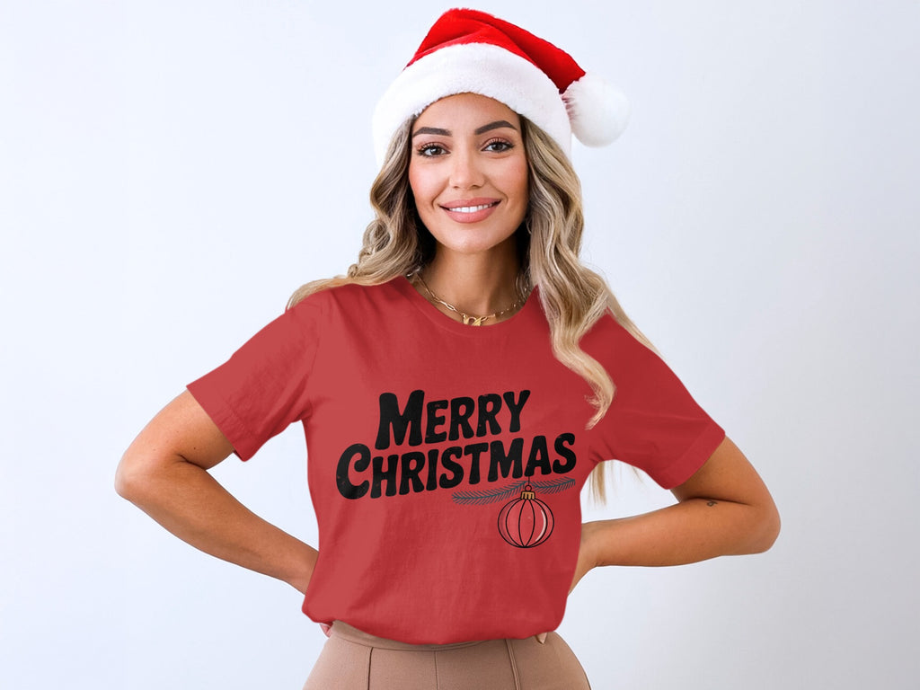 Woman wearing a red t-shirt with "Merry Christmas" and an ornament.
