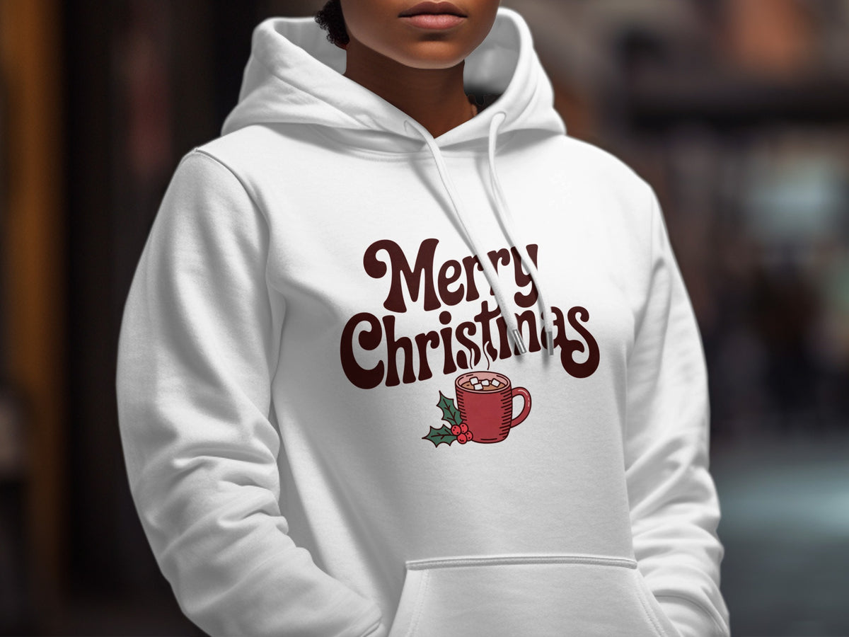 A person wearing a white hooded sweatshirt with Merry Christmas text and a cocoa mug graphic.