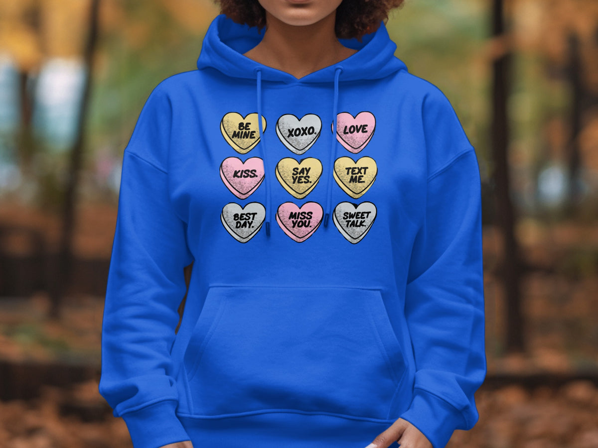 Royal blue hoodie with nine candy heart graphic prints: "Be Mine", "XOXO", "Love", "Kiss", "Say Yes", "Text Me", "Best Day", "Miss You", "Sweet Talk".