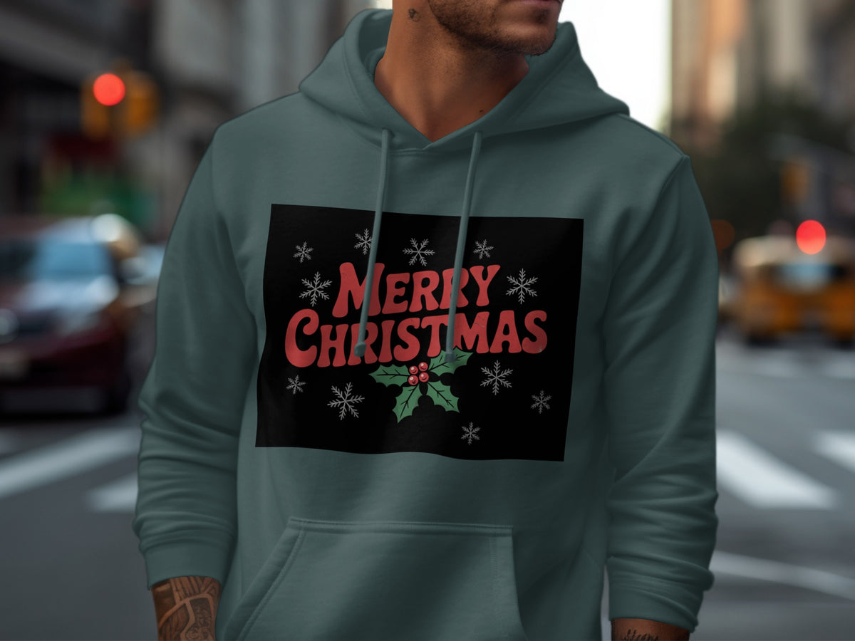 A man wearing a grey hoodie with a Merry Christmas graphic featuring holly and snowflakes.
