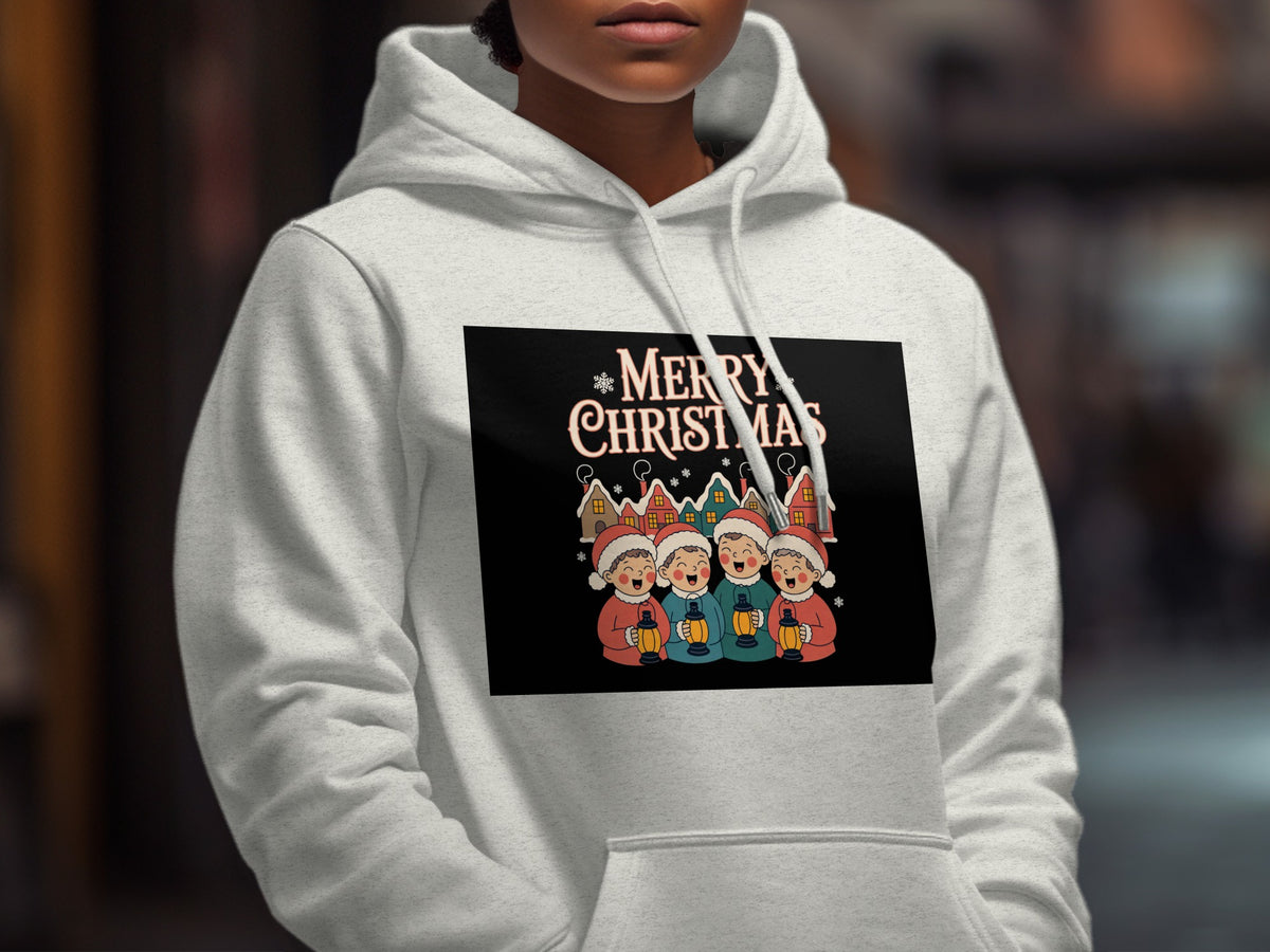 A person wearing a light gray hoodie printed with a Merry Christmas graphic featuring four carolers.