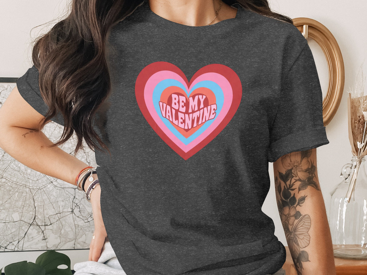 Dark grey t-shirt with concentric hearts graphic and "BE MY VALENTINE" text.