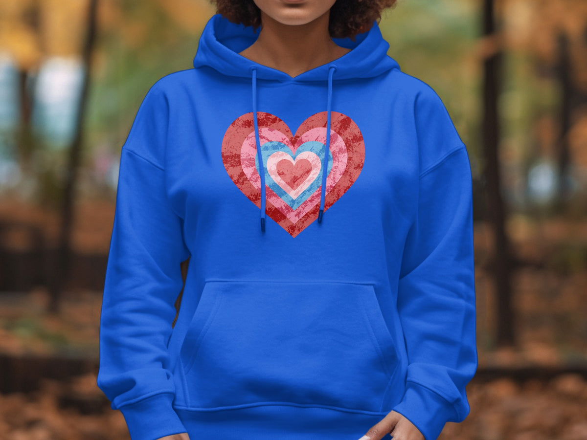 Blue hoodie with layered pink and red heart graphic on chest.