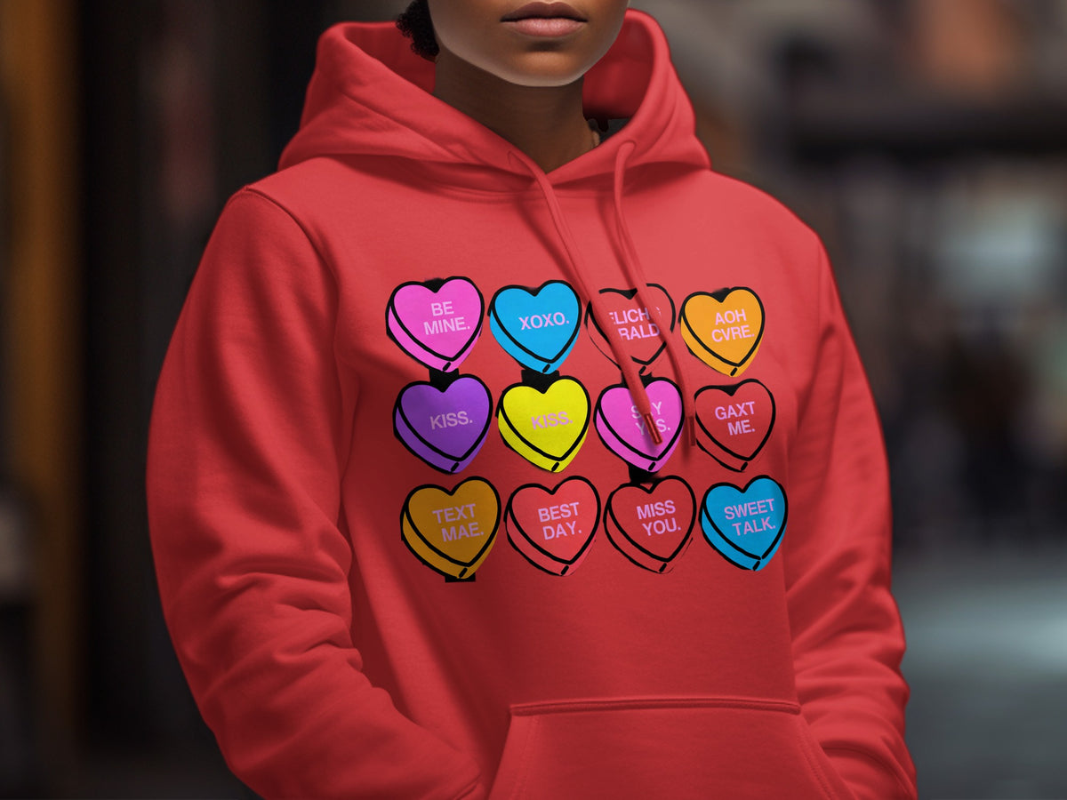Red hoodie with a graphic of colorful candy hearts featuring Valentine's Day phrases.
