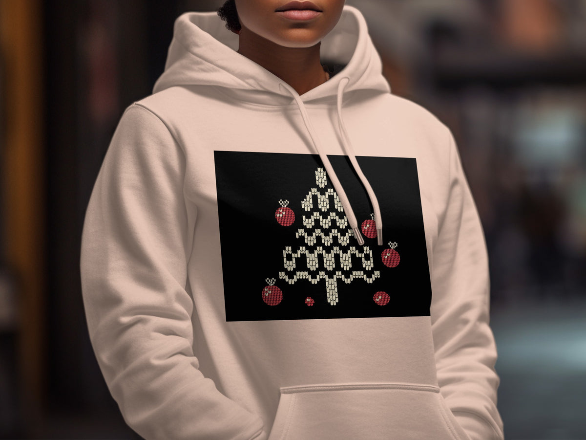 A person wearing a white hoodie featuring a black rectangular graphic of a knitted Christmas tree with ornaments.