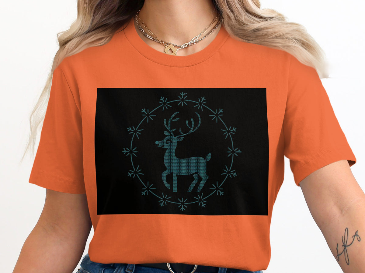 Orange t-shirt with a black rectangular graphic featuring a blue pixelated deer inside a snowflake circle.