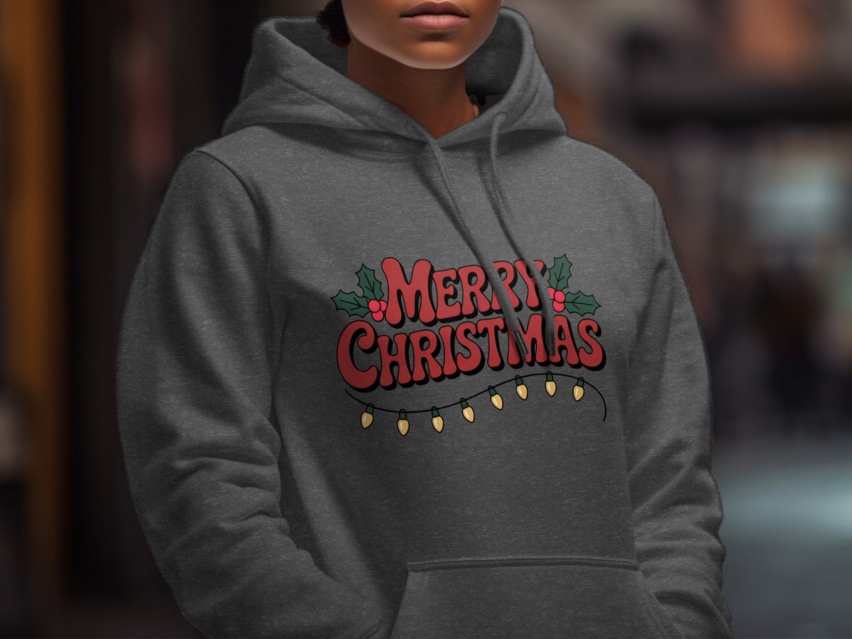 A person wearing a dark gray hoodie with red Merry Christmas text and holiday lights.