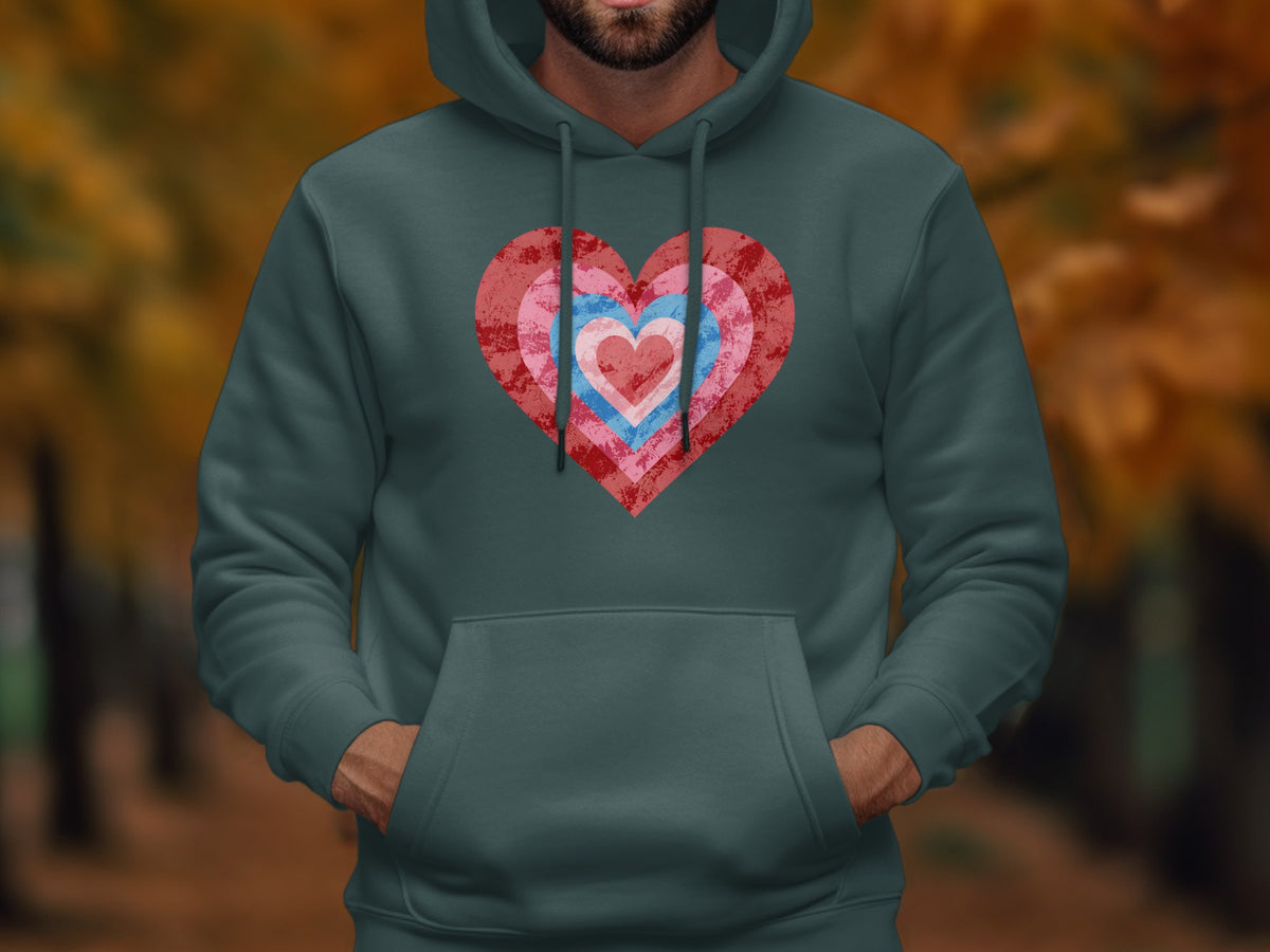 Green hoodie with a textured heart design made of concentric pink and blue rings.