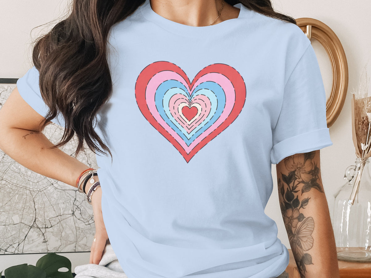 Light blue t-shirt with a colorful concentric heart graphic and rolled-up sleeves.