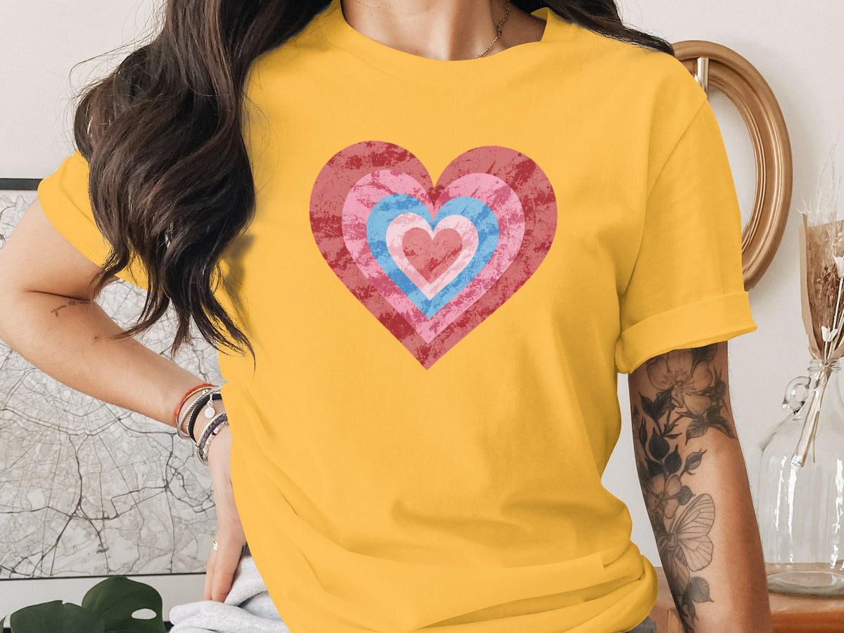 Yellow t-shirt with concentric pink, blue, and red hearts graphic.