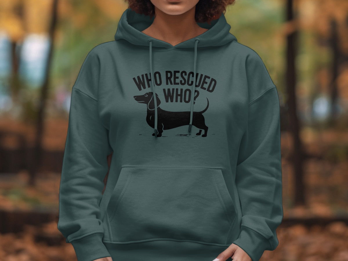 Dark green hoodie with black dachshund graphic and "WHO RESCUED WHO?" text.