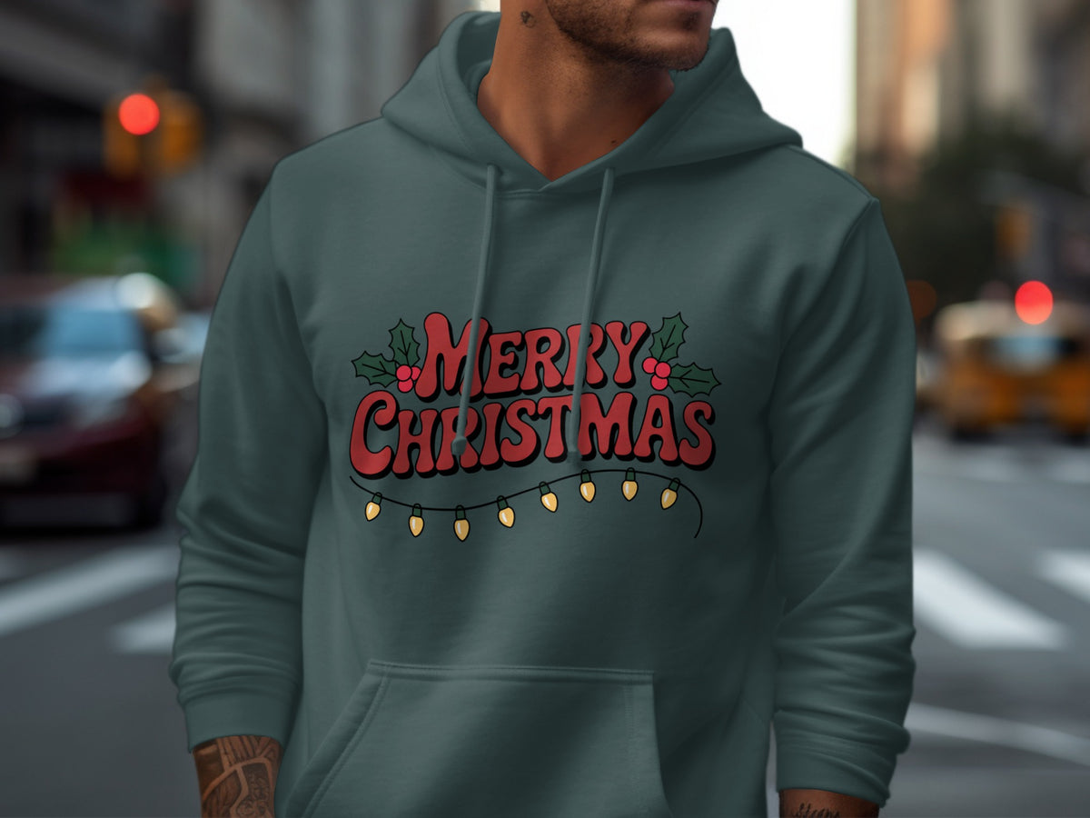 A person wearing a dark teal hoodie featuring red Merry Christmas text and holiday lights.