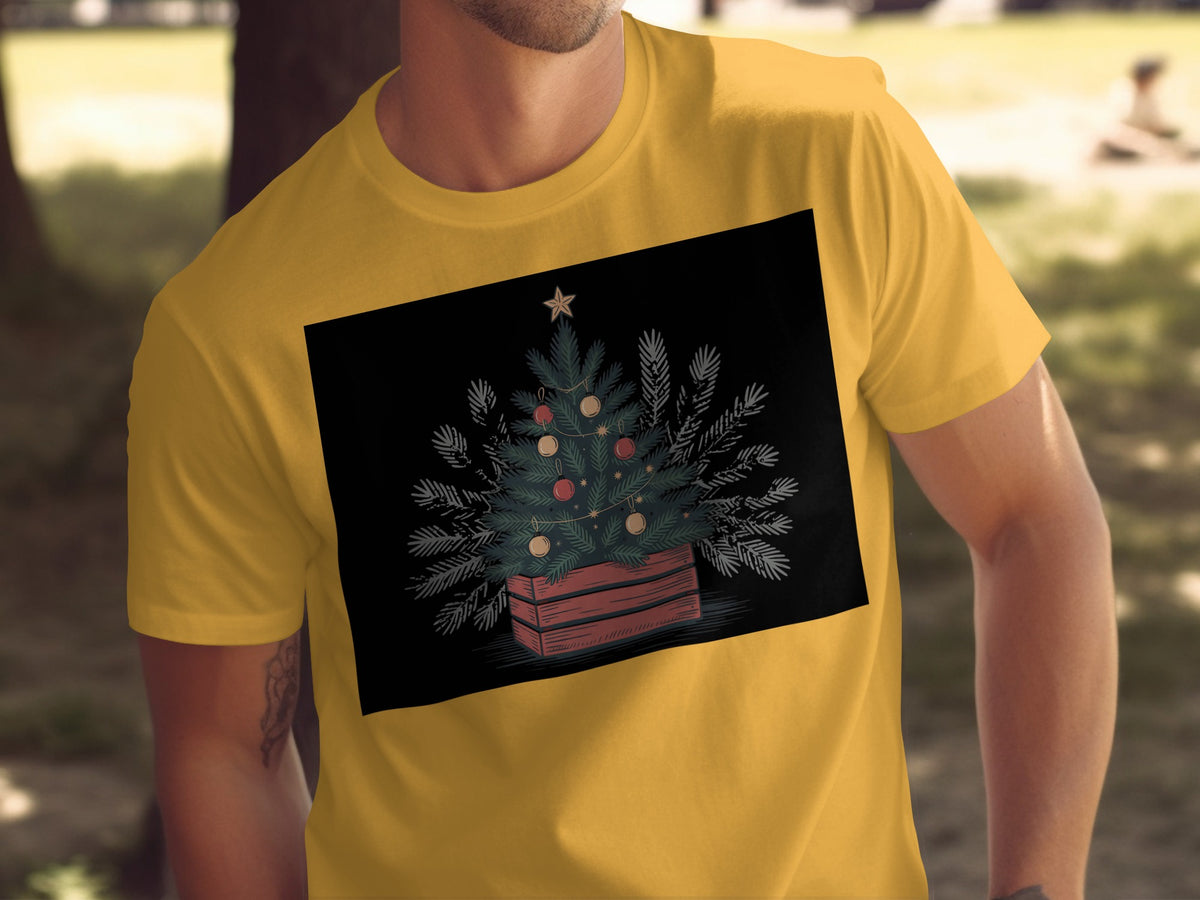 Yellow t-shirt with a Christmas tree design in a wooden crate on black background.
