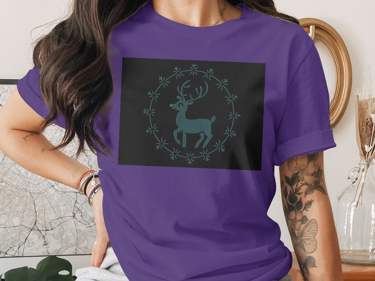 Purple t-shirt with a dark square graphic of a reindeer in a snowflake wreath.