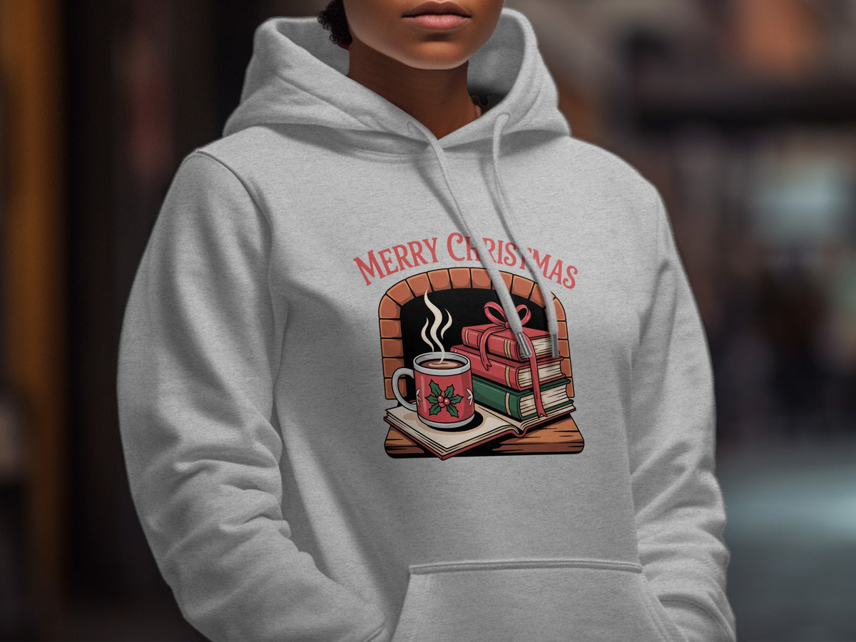 A person wearing a light gray hoodie printed with a Merry Christmas fireplace graphic.