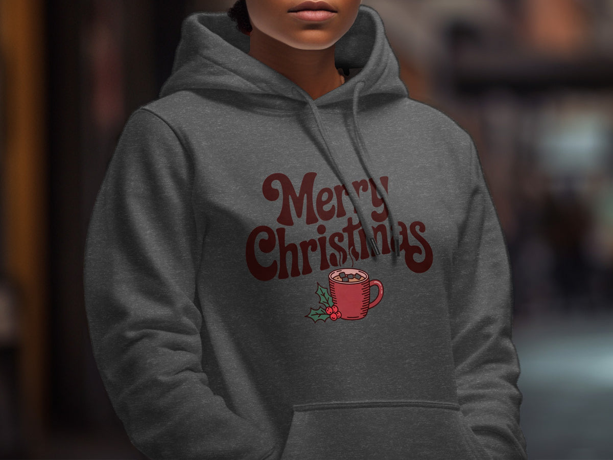 A person wearing a dark gray hoodie with red Merry Christmas text and a cocoa mug graphic.