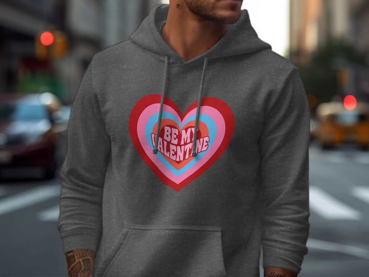 Dark grey hoodie with a layered heart graphic reading "BE MY VALENTINE".