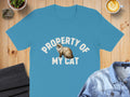 Turquoise t-shirt with "PROPERTY OF MY CAT" and a fluffy cat graphic.