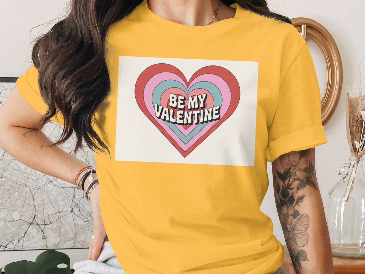 Yellow t-shirt with a heart graphic that reads "BE MY VALENTINE".