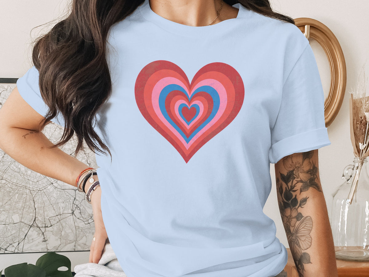 Light blue t-shirt with nested heart graphic in red, pink, and blue.