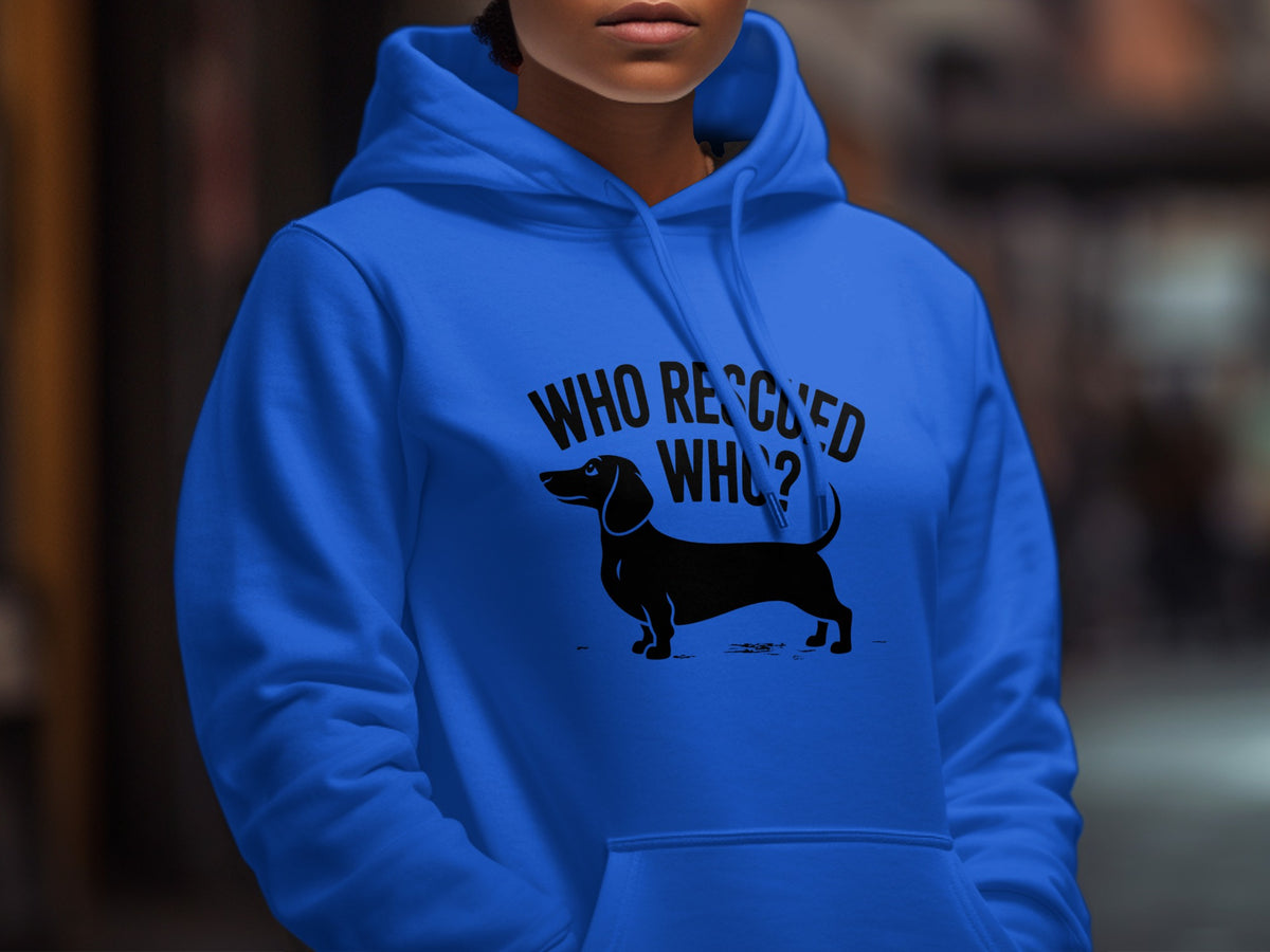 Blue hoodie with black graphic of a dachshund and text "WHO RESCUED WHO?".