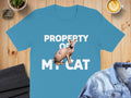 Blue t-shirt with "PROPERTY OF MY CAT" and a Sphynx cat graphic.
