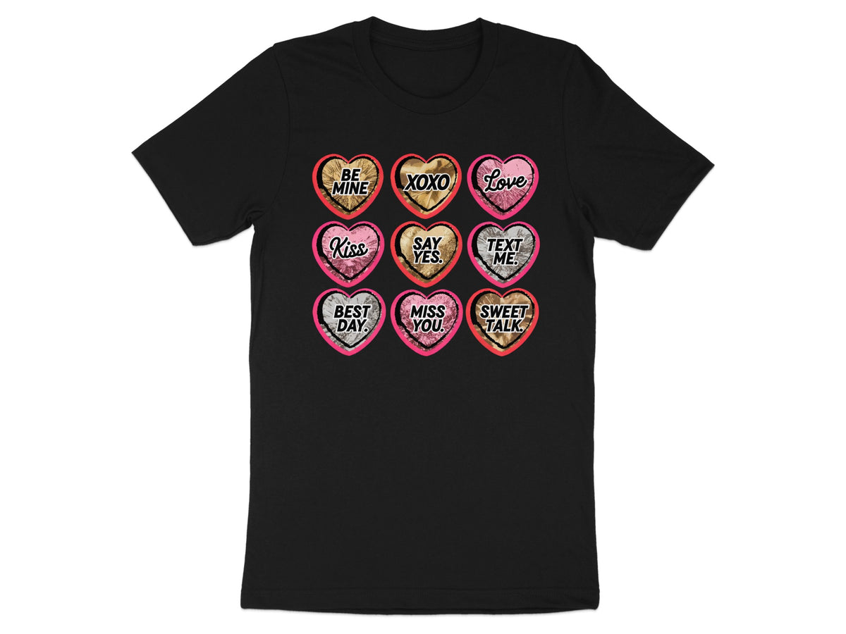 A black t-shirt printed with a 3x3 grid of colorful candy hearts featuring various romantic messages.