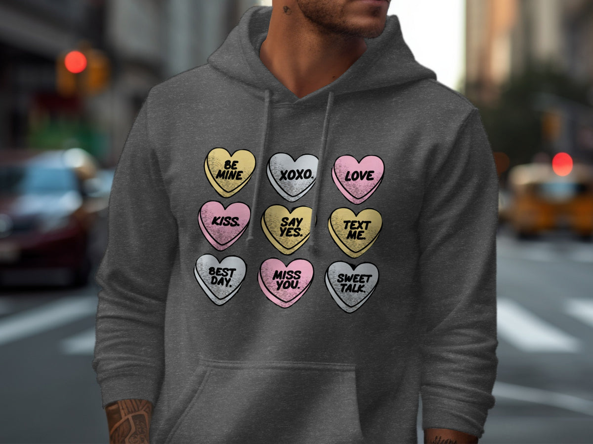Dark grey hoodie with candy hearts reading "Be Mine", "XOXO", "Love", "Kiss", "Say Yes", "Text Me", "Best Day", "Miss You", "Sweet Talk".