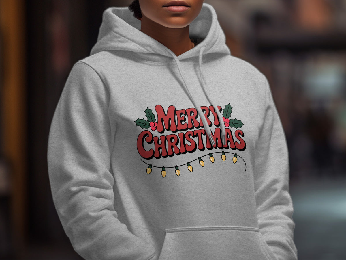 A person wearing a grey hoodie featuring a Merry Christmas graphic with holly and lights.