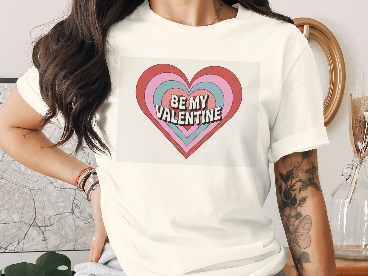 Cream t-shirt with concentric hearts graphic and "BE MY VALENTINE" text.