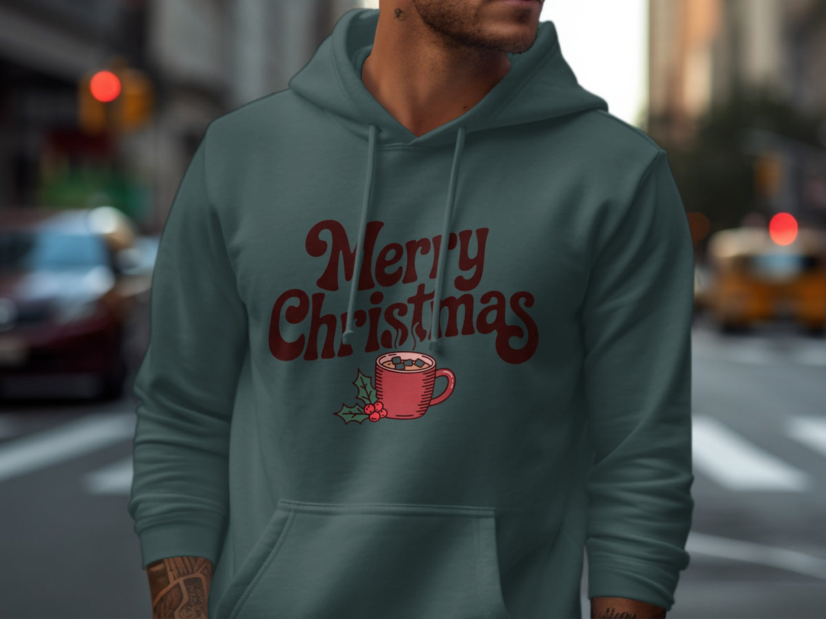 A man wearing a slate blue hoodie printed with Merry Christmas and a steaming mug graphic.
