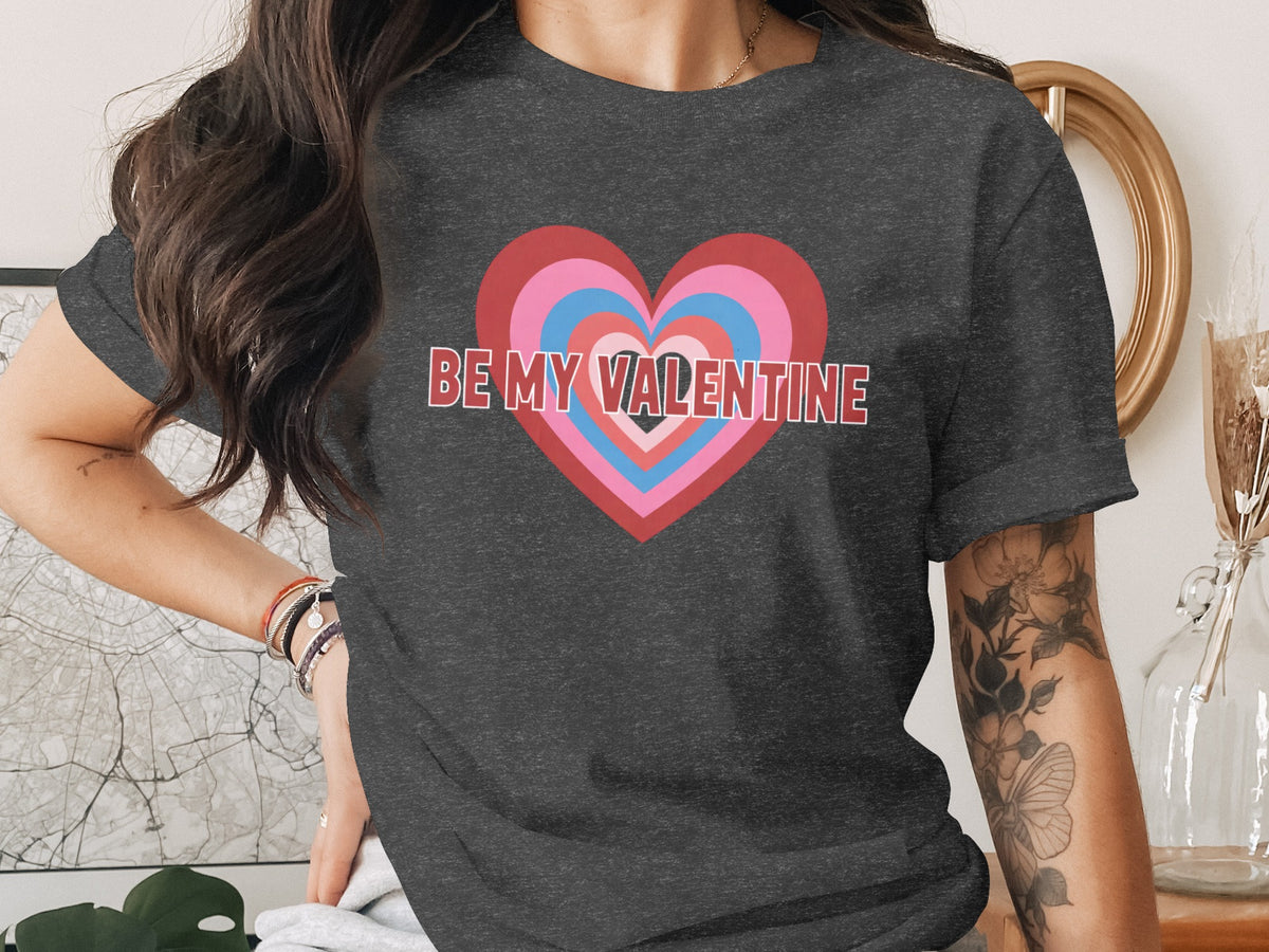 Dark t-shirt with concentric hearts and "BE MY VALENTINE" text.