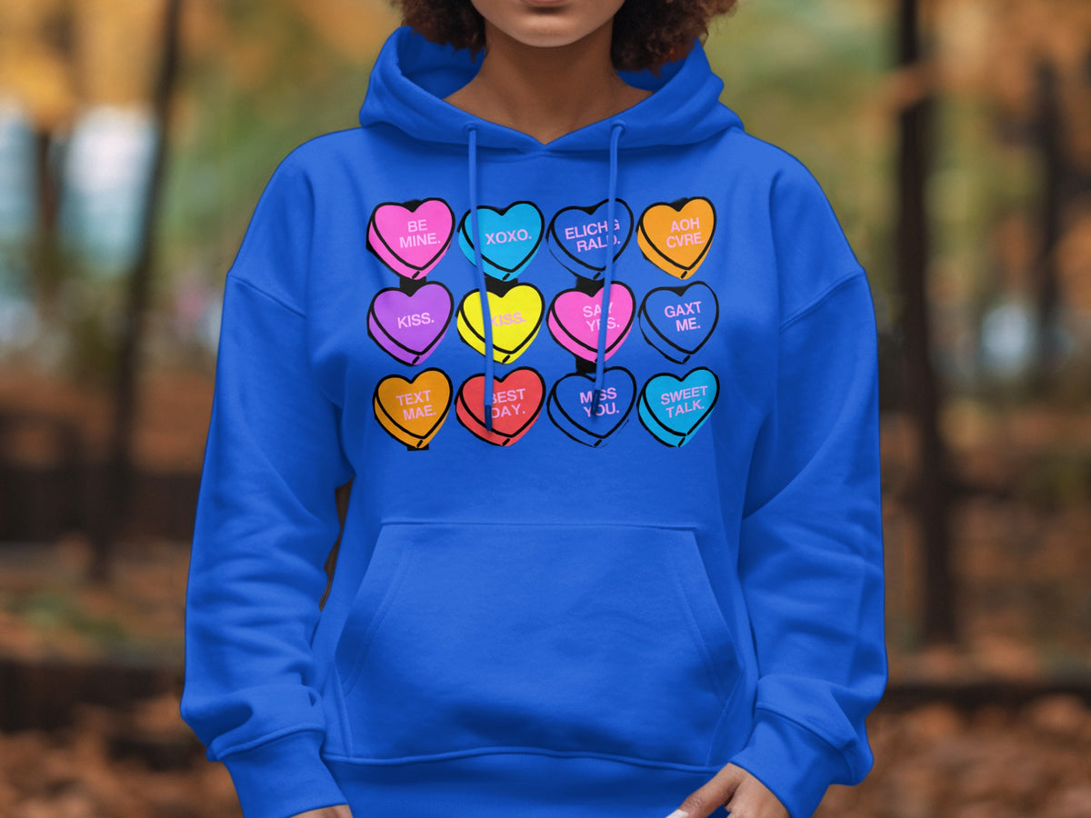 Blue hoodie with conversation hearts featuring phrases like "Be Mine," "XOXO," and "Sweet Talk."