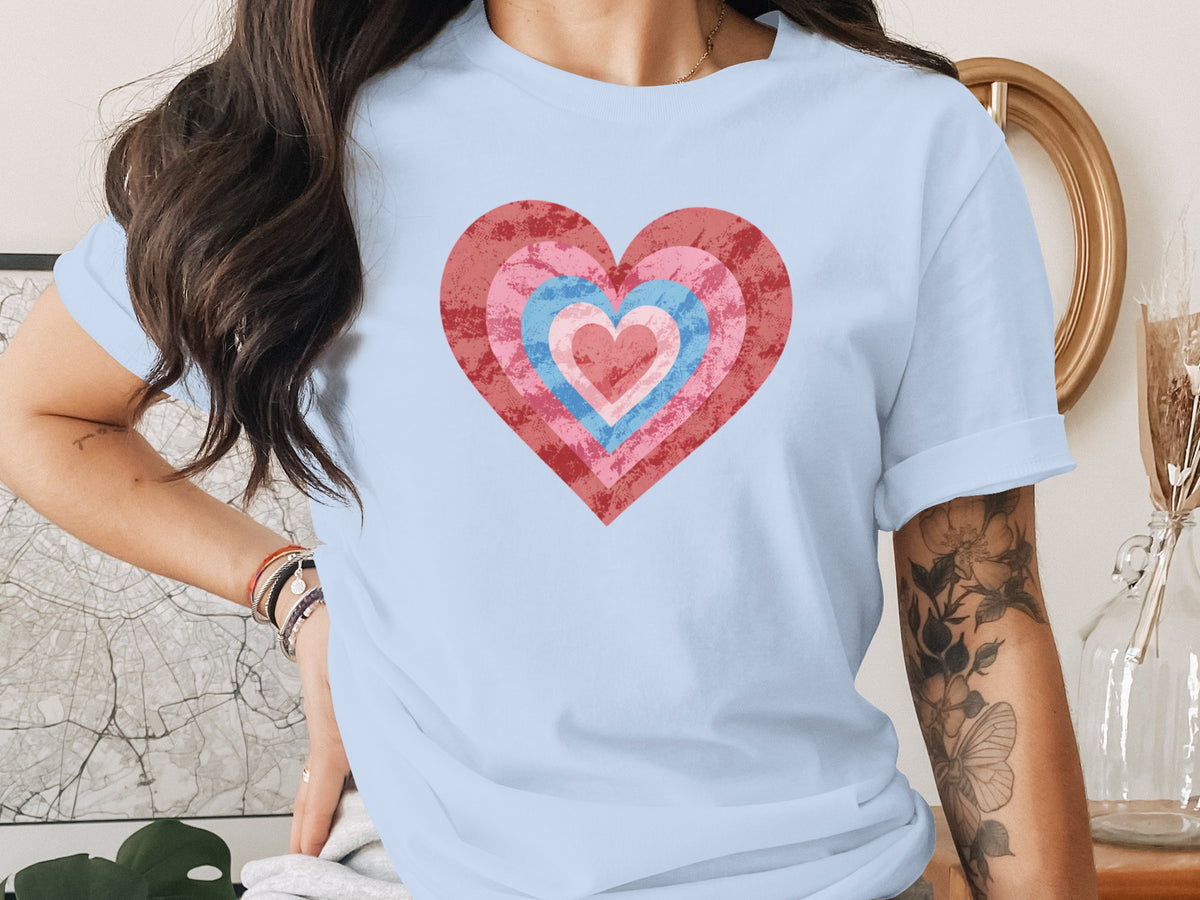 Light blue t-shirt with concentric hearts graphic in pink and blue hues.