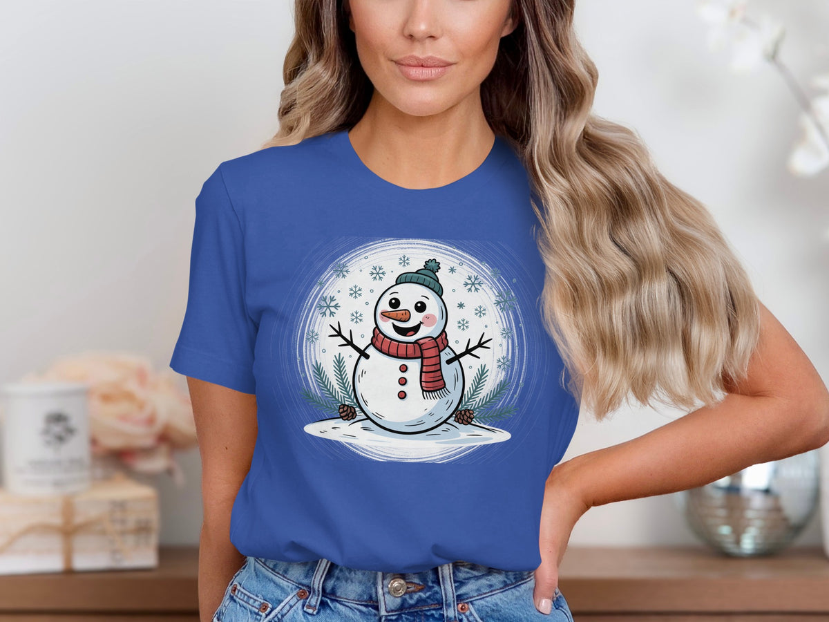 Blue t-shirt with a cartoon snowman wearing a hat and scarf surrounded by snowflakes.