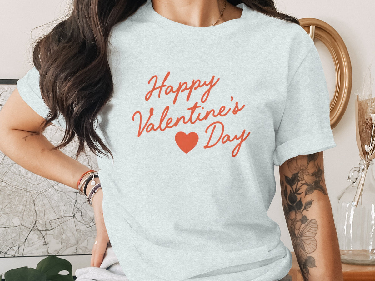 A person wearing a light blue t-shirt printed with red script text reading Happy Valentine's Day and a red heart.