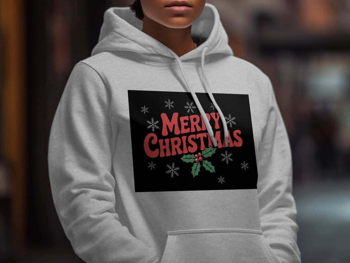 A person wears a light gray hoodie with a black chest graphic featuring red Merry Christmas text, holly leaves, and snowflakes.