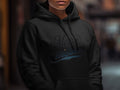 A person wearing a black hooded sweatshirt with the text Merry Christmas printed across the chest.